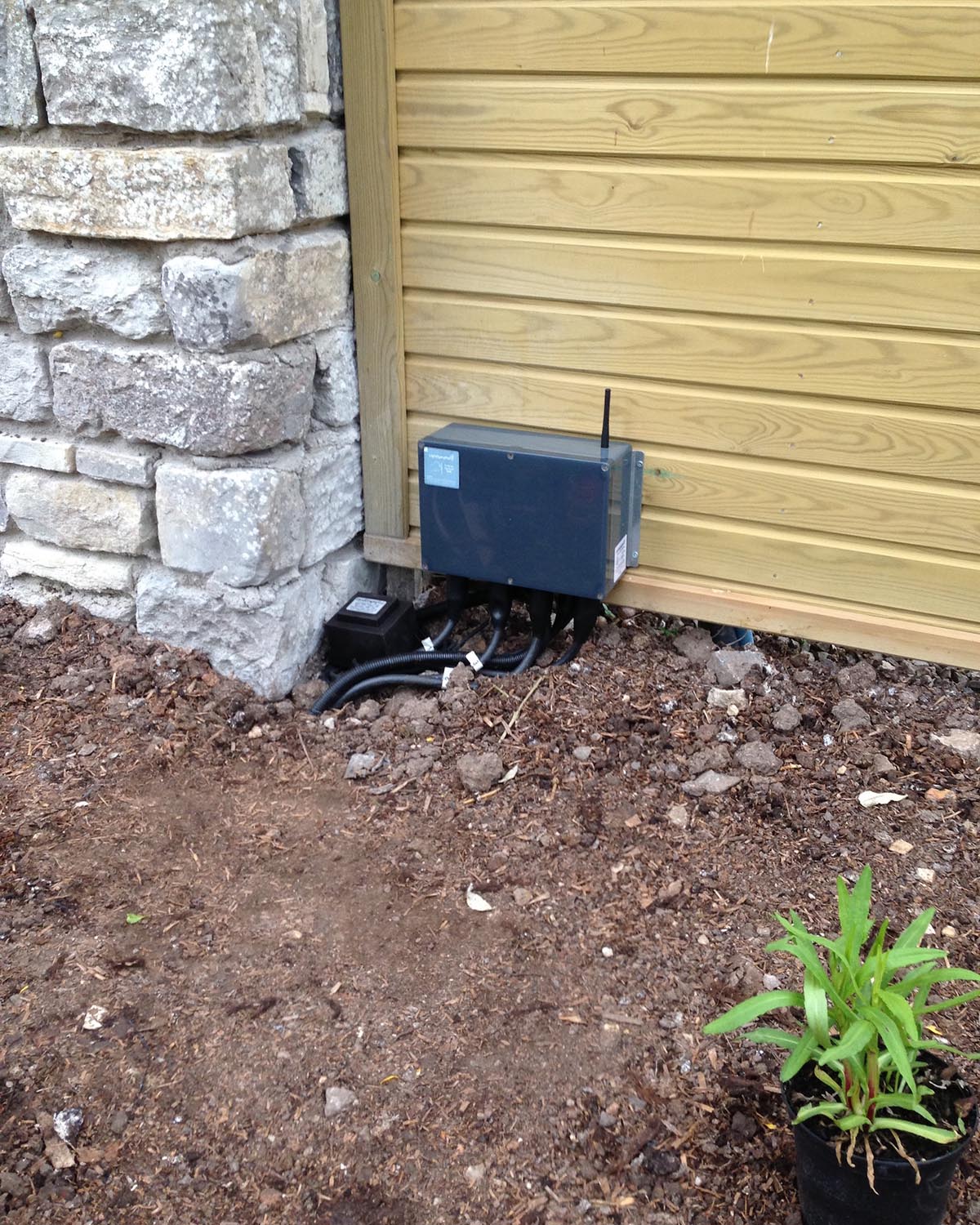 Black power box in corner of outside building. NBG Digital Home. Electric Vehicle chargers, Solar and Heat Pumps, General Electrical Services in the South West.